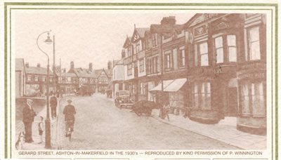 Artist impression of Gerard Street in the 1930s. The street is lined with shops and tall brick and timber‑framed buildings. A cyclist rides toward the camera, and a few pedestrians stand along the pavement. A vintage car is parked on the right, and an ol