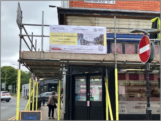 Banner on the scaffolding showing that the project is government funded through the building grant scheme.
