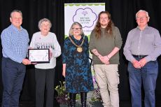 Five people with their award in front of a pull up banner